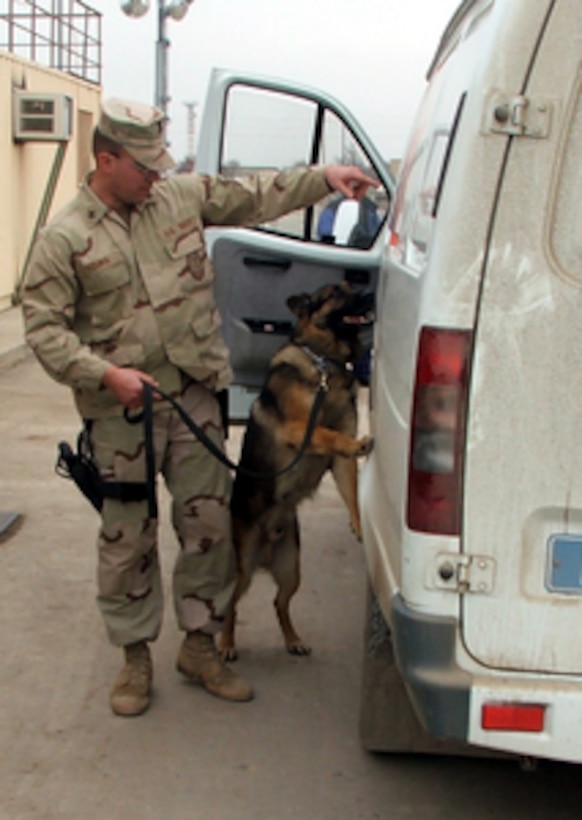 U.S. Navy Petty Officer 1st Class Patrick Yourg and his military working dog Cven check a vehicle at the main entry gate at Karshi-Khanabad Air Base, Uzbekistan, on Feb. 1, 2005. Yourg is a Navy Master of Arms assigned as a dog handler with the 13th Military Police Detachment. 