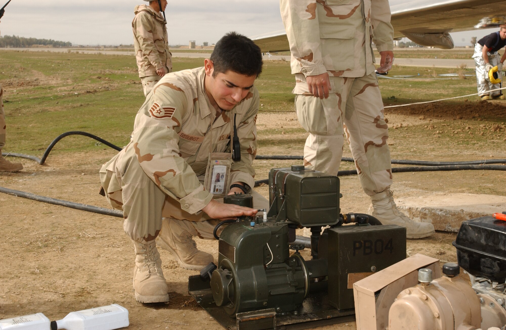 KIRKUK AIR BASE, Iraq -- Staff Sgt. Victor Seguinot prepares to start an air compressor to fill airbags used to raise the wing of an aircraft mired in mud.  The airbags are capable of lifting 12 tons of weight.  (U.S. Air Force photo by Staff Sgt. Matthew Lohr)