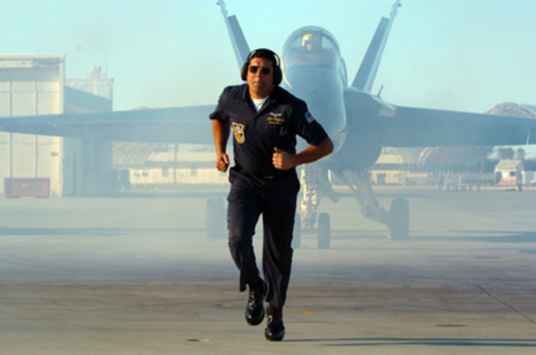 Petty Officer 1st Class Eric Velazquez moves to a safe location as a Blue Angel F/A-18A Hornet starts to taxi down the airfield at Naval Air Facility El Centro, Calif., on Feb. 2, 2005. The Blue Angels are at El Centro for their annual winter training. The 10-week winter training will conclude in early March after the team completes a minimum of 120 flights during a rigorous six- days-a-week, three-flights-per-day schedule. Velazquez is a Navy aviation ordnanceman. 