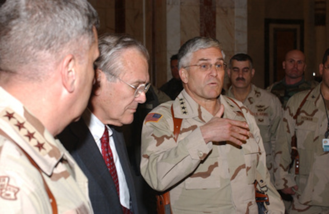 Commander of Multi-National Force Iraq Gen. George Casey Jr. (right), U.S. Army, answers a reporter's question during a media availability with Secretary of Defense Donald H. Rumsfeld (center) and Commander U.S. Central Command Gen. John Abizaid, (left) U.S. Army, in Baghdad, Iraq, on Feb. 11, 2005. Rumsfeld made a surprise visit to Iraq to meet with the senior leadership and the troops deployed there. 