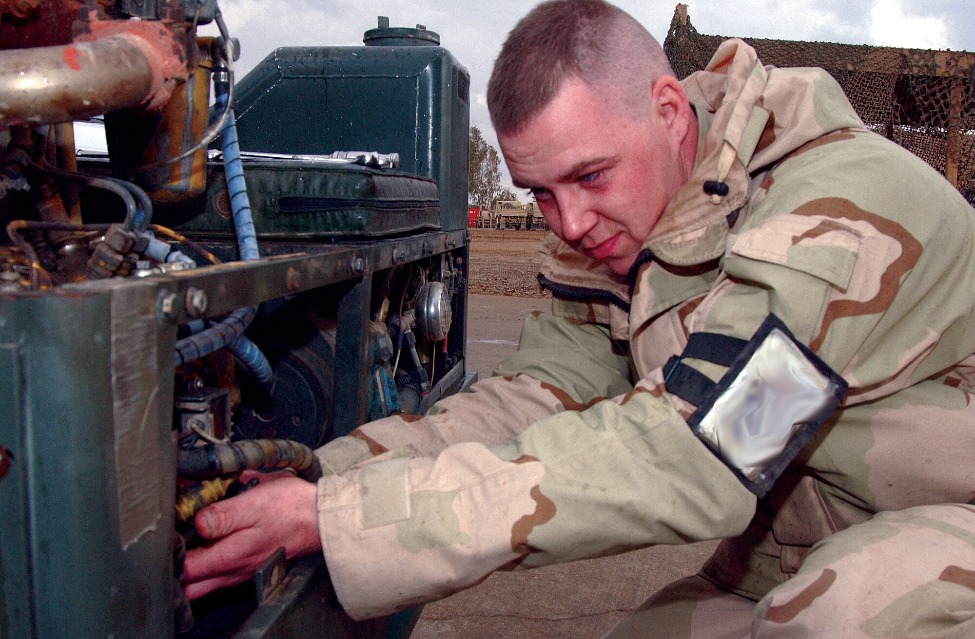 BALAD AIR BASE, Iraq, -- Airman 1st Class Todd Spencer changes the starter on a bomb lift used to raise missiles and bombs being mounted onto an aircraft.  Besides flightline operations, he and other 332nd Expeditionary Maintenance Squadron Aerospace Ground Equipment Airmen help civil engineers provide power to housing areas here.  (Digitally altered U.S. Air Force photo by Senior Airman Colleen Wronek)