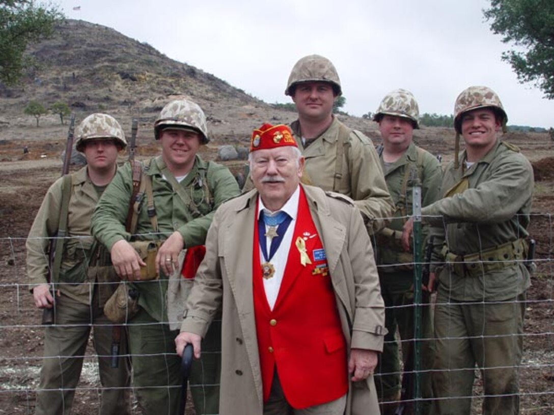 Pfc. Jack Lucas, the youngest World War II Medal of Honor recipient, visits role players during a battle of Iwo Jima reenactment in Fredericksburg, Texas in 2005. Lucas received his Medal of Honor for shielding three Marines from two grenades with his body during the battle of Iwo Jima.