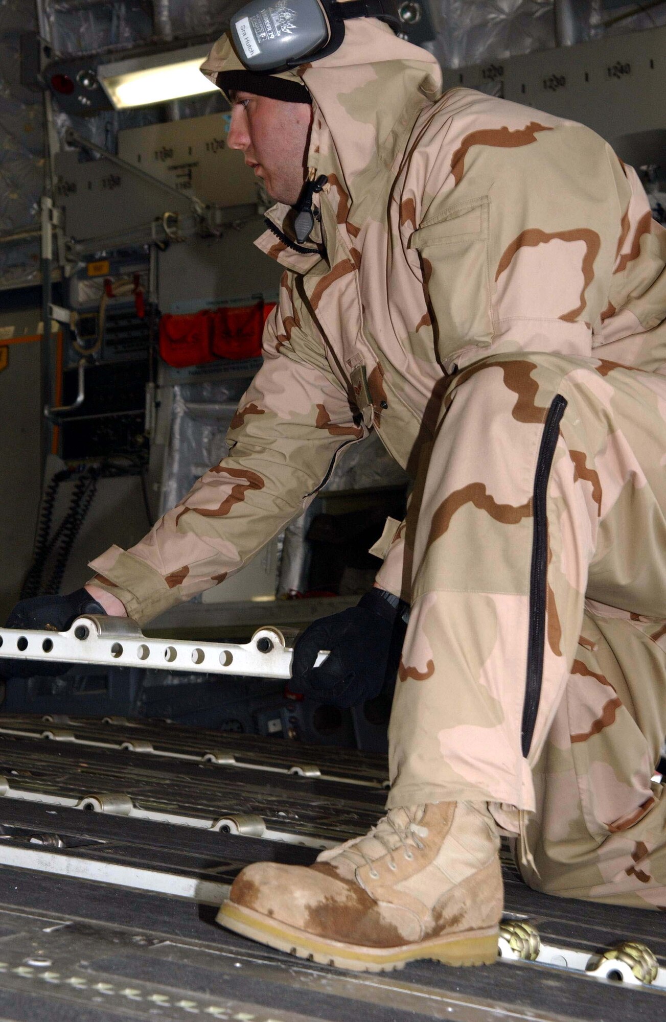 BAGRAM AIR BASE, Afghanistan -- Senior Airman Robert Hutchinson prepares a C-17 Globemaster III to receive cargo by flipping over the tracks in the aircraft floor for easy loading.  Airman Hutchinson is an air transportation specialist with the 455th Expeditionary Logistics Readiness Squadron here, deployed from Dobbins Air Reserve Base, Ga.  (U.S. Air Force photo by Capt. Catie Hague)
