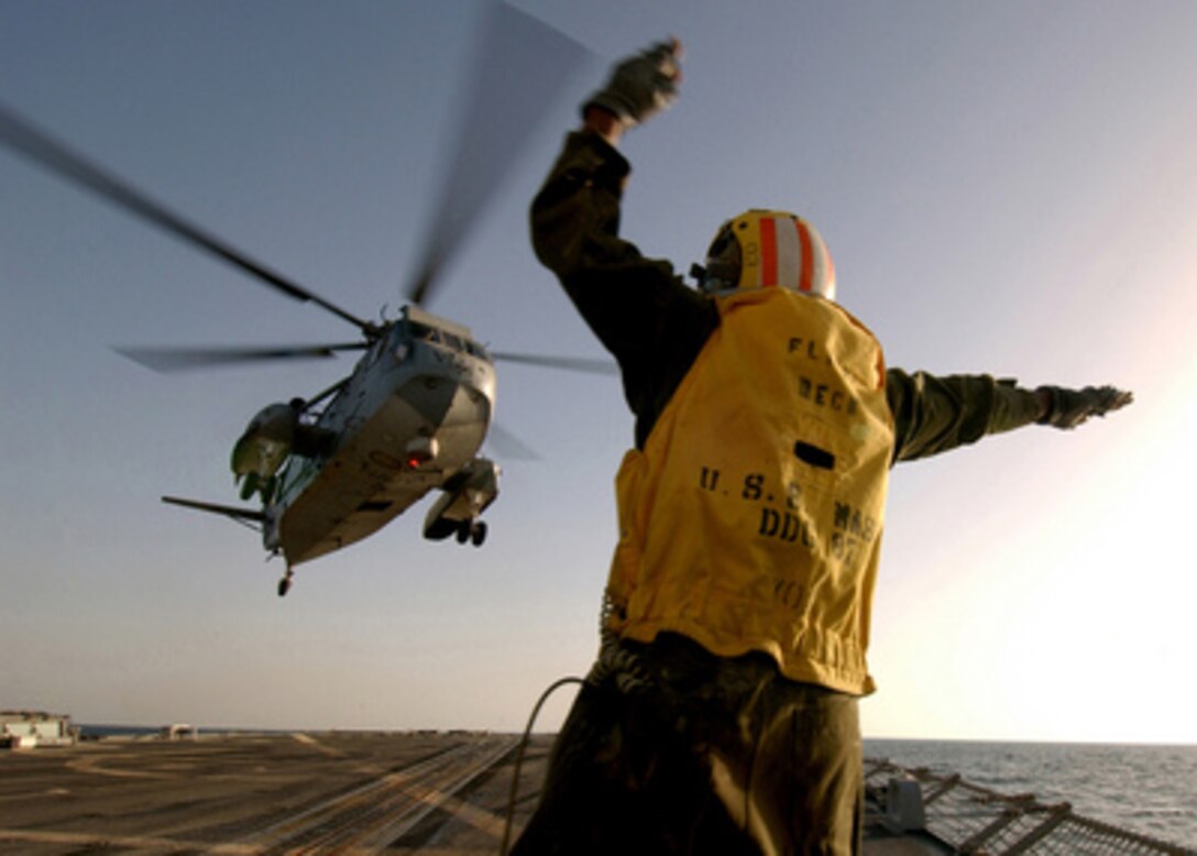 Petty Officer 2nd Class Itro Duncan signals the pilot of an H-3 Sea King helicopter that it is clear to move away from the flight deck of the USS Mason (DDG 87) as the ship operates in the Persian Gulf on Feb. 5, 2005. The Arleigh Burke class destroyer is conducting operations in the Gulf as a part of Destroyer Squadron 26 and the USS Harry S. Truman (CVN 75) Carrier Strike Group. The Sea King, from Helicopter Combat Support Squadron 2, and the USS Mason are both deployed from Norfolk, Va. 