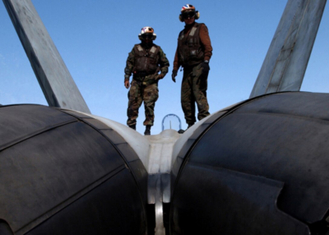 Marine plane captains Cpl. Lee Sanders (left) and Lance Cpl. Michael Miller inspect an F/A-18A+ Hornet prior to the start of flight operations aboard the aircraft carrier USS Harry S. Truman (CVN 75) on Feb. 12, 2005. The Truman Strike Group and Carrier Air Wing 3 are conducting close air support, intelligence, surveillance, and reconnaissance missions over Iraq. Sanders and Miller are assigned to Marine Fighter Attack Squadron 115 of Marine Corps Air Station Beaufort, S.C. 