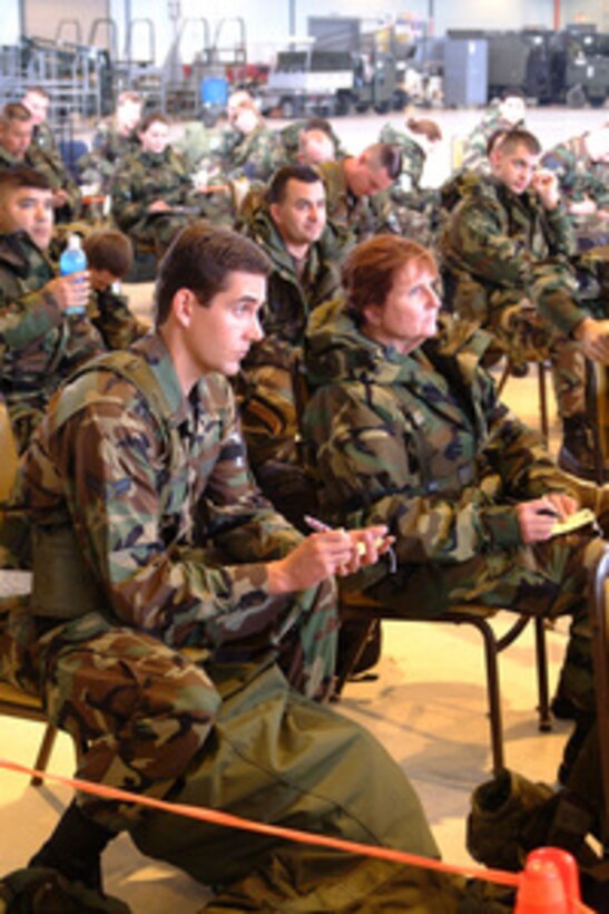 U.S. Air Force Airman 1st Class William Becker (left) and Master Sgt. Karin Porter (right) listen to instructions as they process through the mobility processing containment center at Fresno Air National Guard Base, Fresno, Calif., during an operational readiness inspection on Feb. 11, 2005. Becker and Porter are assigned to the 144 Fighter Wing. 