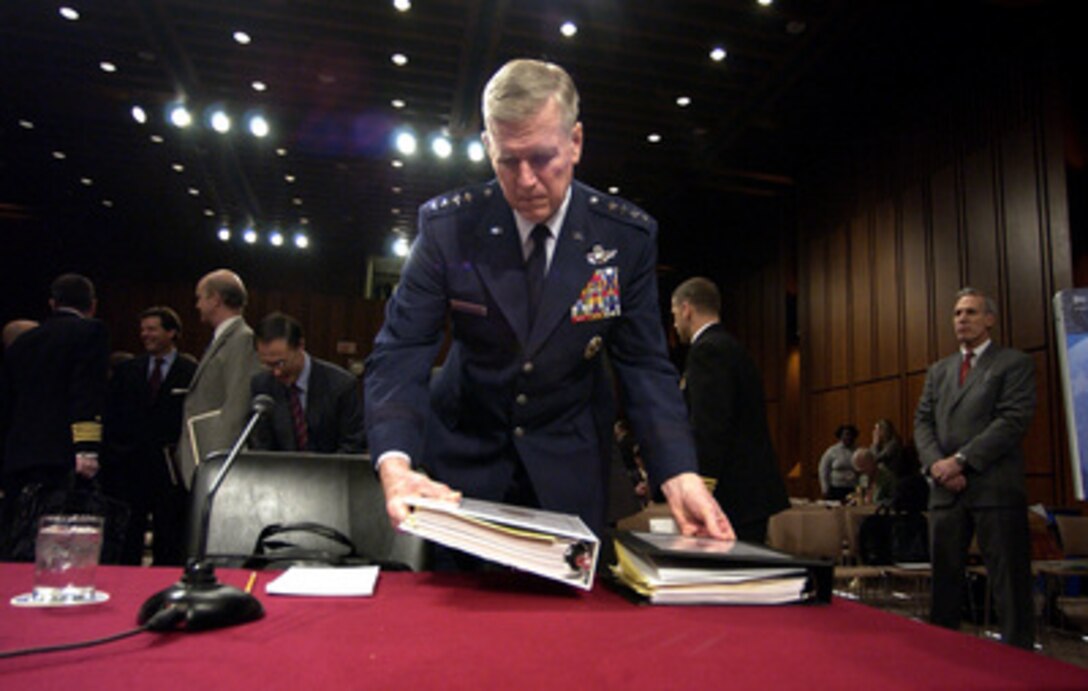 Chairman of the Joint Chiefs of Staff Gen. Richard B. Myers, U.S. Air Force, lays down his notebooks as he prepares for a Senate Armed Services Committee hearing in the Hart Senate Office Building in Washington, D.C., on Feb. 17, 2005. Myers, Secretary of Defense Donald H. Rumsfeld and Under Secretary of Defense Comptroller Tina Jonas are testifying before the committee. 