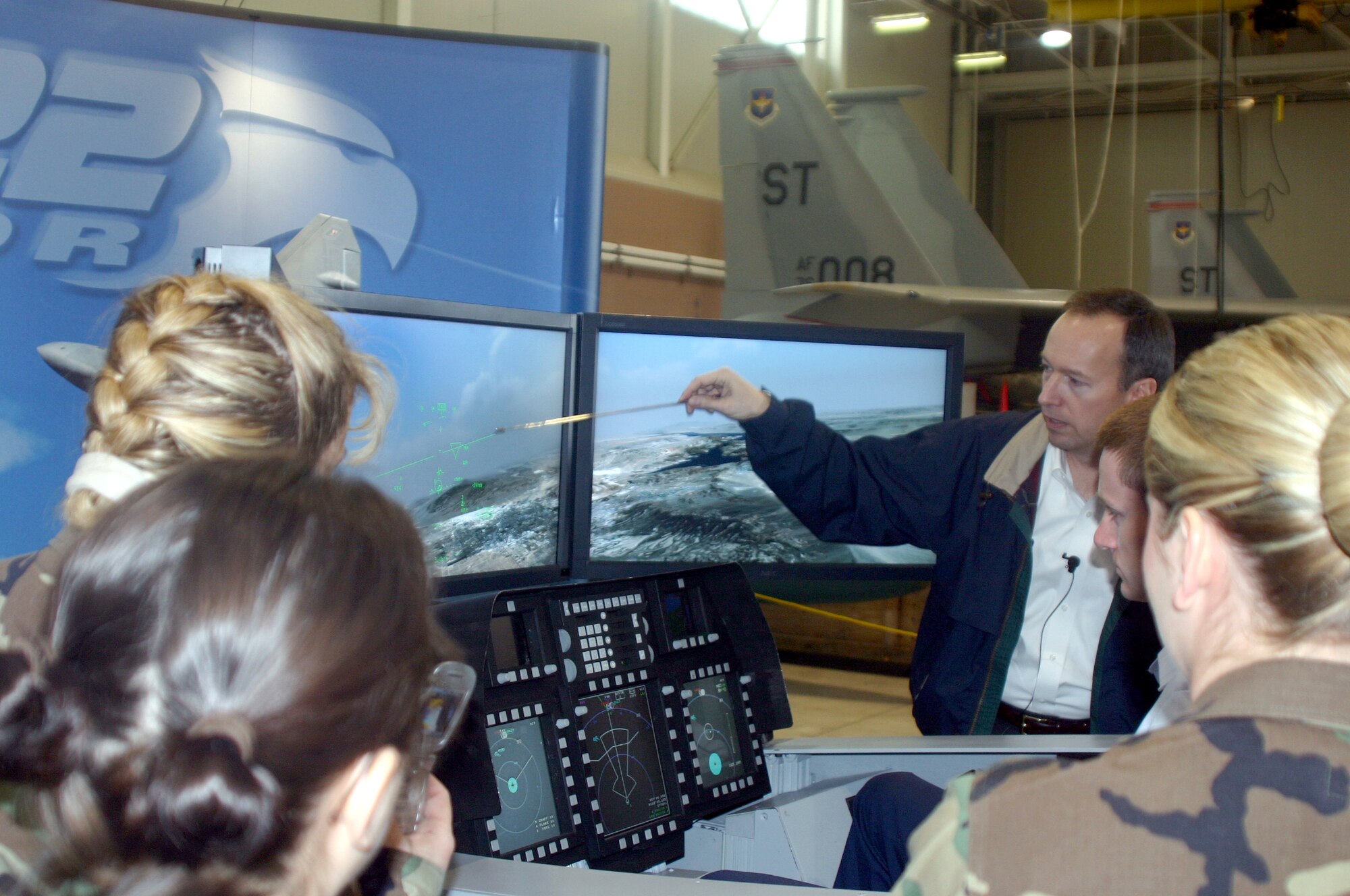 SHEPPARD AIR FORCE BASE, Texas -- Contractor Rich Briggs explains some of the features of the heads-up display of the F/A-22 Raptor simulator to Airmen here.  Contractors brought the demonstrator to give base Airmen a glimpse of the future of fighters in the Air Force.  (U.S. Air Force photo by John Ingle)
