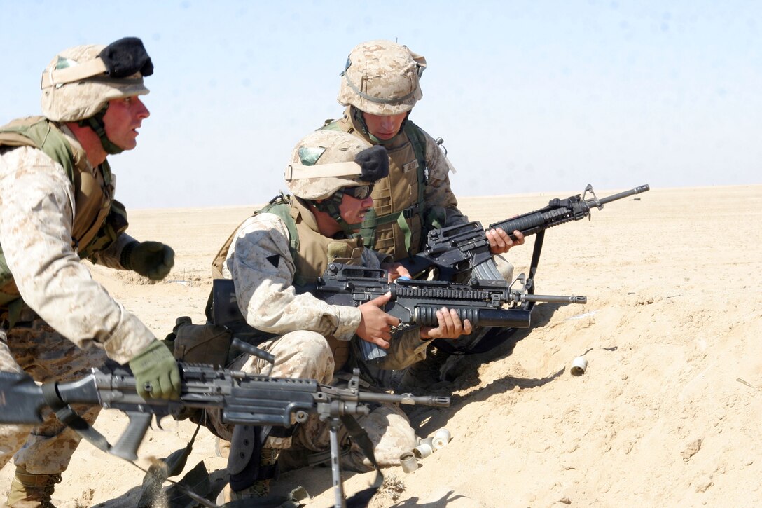 UDAIRI RANGE, Kuwait (Feb. 18, 2005) -- Marines with A Co., Battalion Landing Team 1/1 take cover behind a berm, while getting ready to fire an M 203 grenade launcher during live-fire squad rushes. BLT 1/1, attached to the 15th Marine Expeditionary Unit (Special Operations Capable), is training in Kuwait to maintain their combat effectiveness.