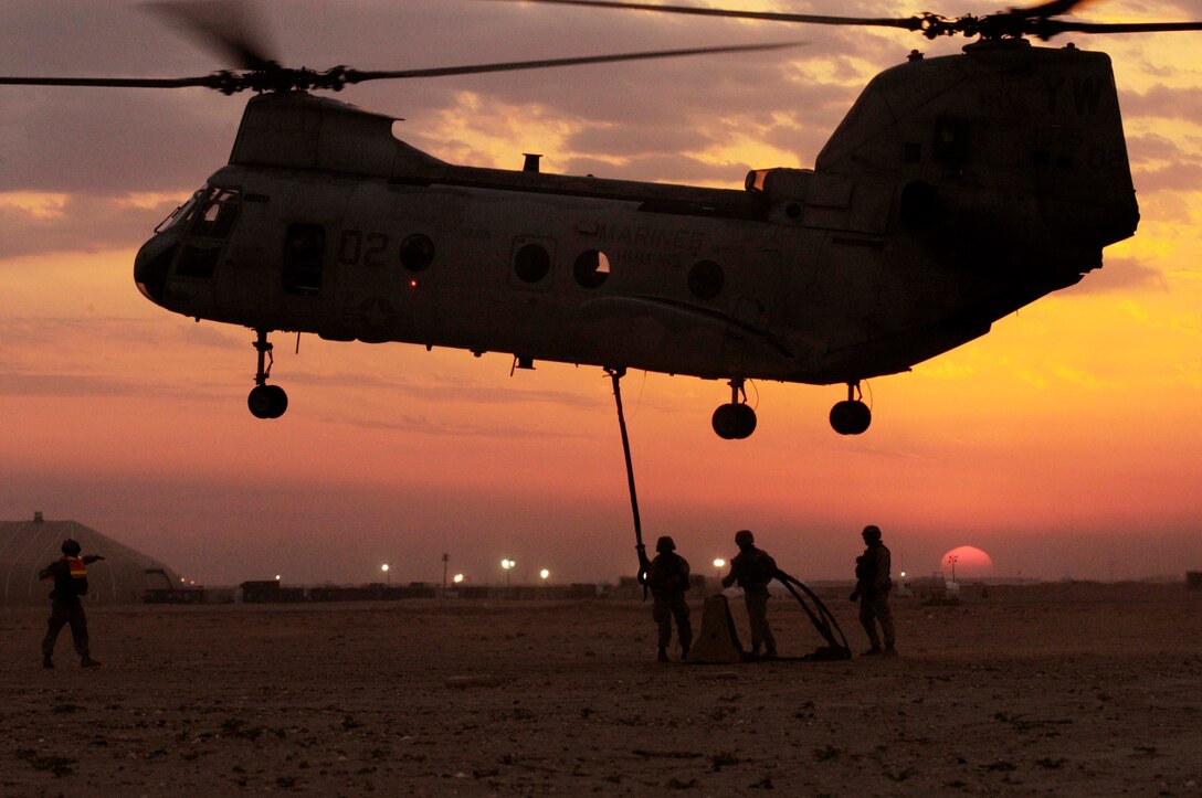 UDAIRI RANGE, Kuwait -- (Feb. 18, 2005) - Against a desert sunset, a Helicopter Suspension Team from MEU Service Support Group 15 connect an external load to a CH-46E helicopter during external load training. The helicopter belongs to Marine Medium Helicopter Squadron 165 (REIN). (Official USMC Photo by Gunnery Sgt. Robert Knoll)