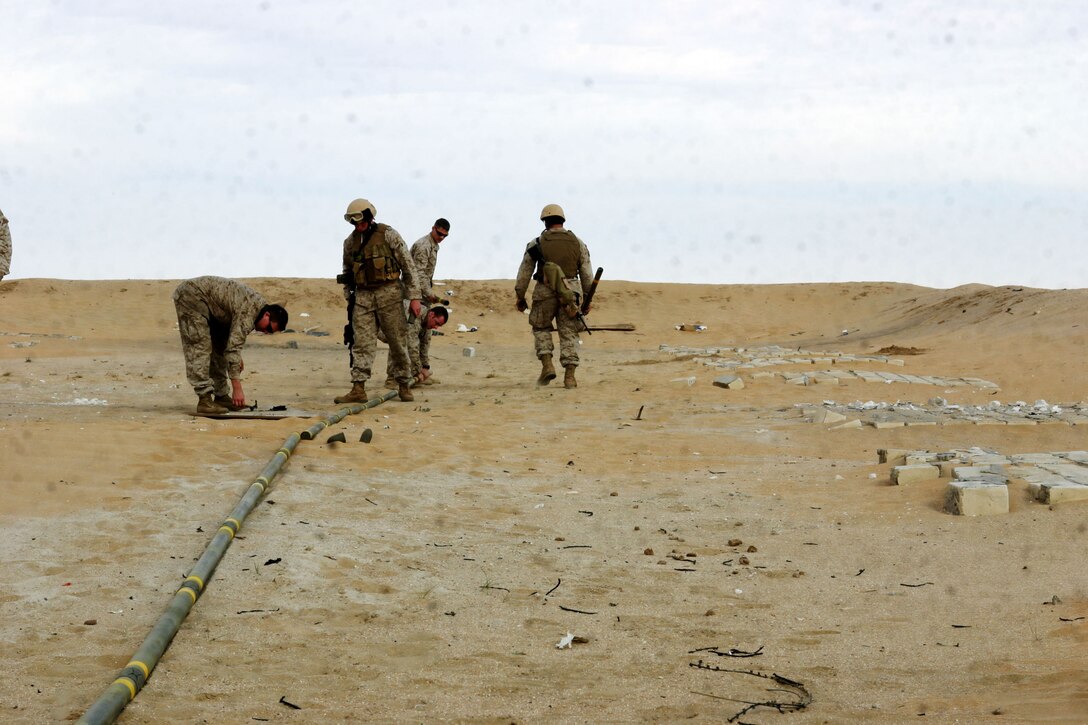 UDAIRI RANGE, Kuwait (Feb. 18, 2005) -- Marines attached to the 15th Marine Expeditionary Unit (Special Operations Capable), make a line of Bangalore torpedoes to see how much impact they will make during their demolitions training. The Marines took part in demo training to better understand explosives and their capabilities. The 15th MEU (SOC) is training in Kuwait to maintain their combat readiness.