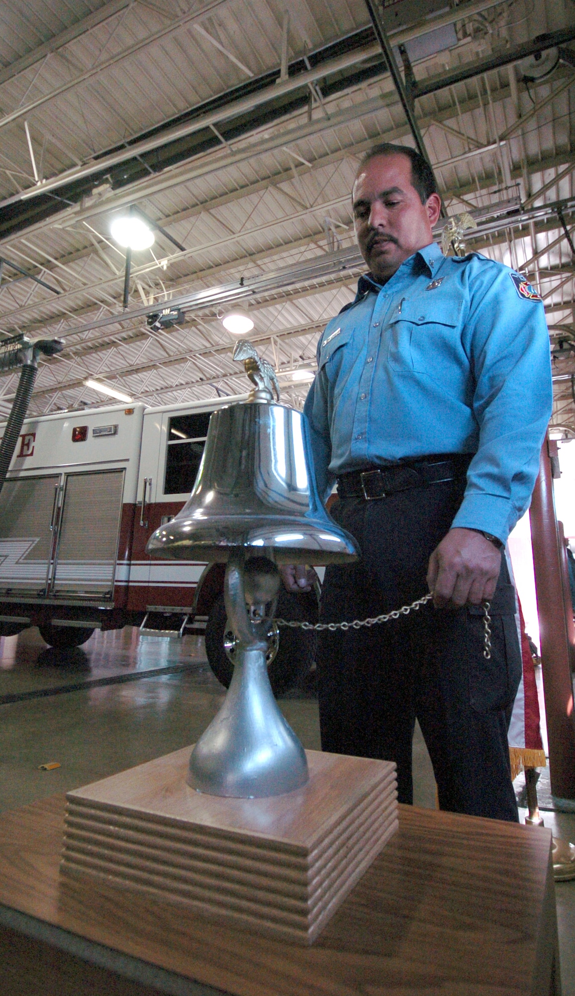RANDOLPH AIR FORCE BASE, Texas -- Firefighter Joe Martinez tolls the bell during a one-minute "final alarm" ceremony Feb. 16 honoring Staff Sgt. Ray Rangel who died while attempting to rescue two Soldiers after their Humvee overturned in a canal in Iraq.  (U.S. Air Force photo by Steve White)