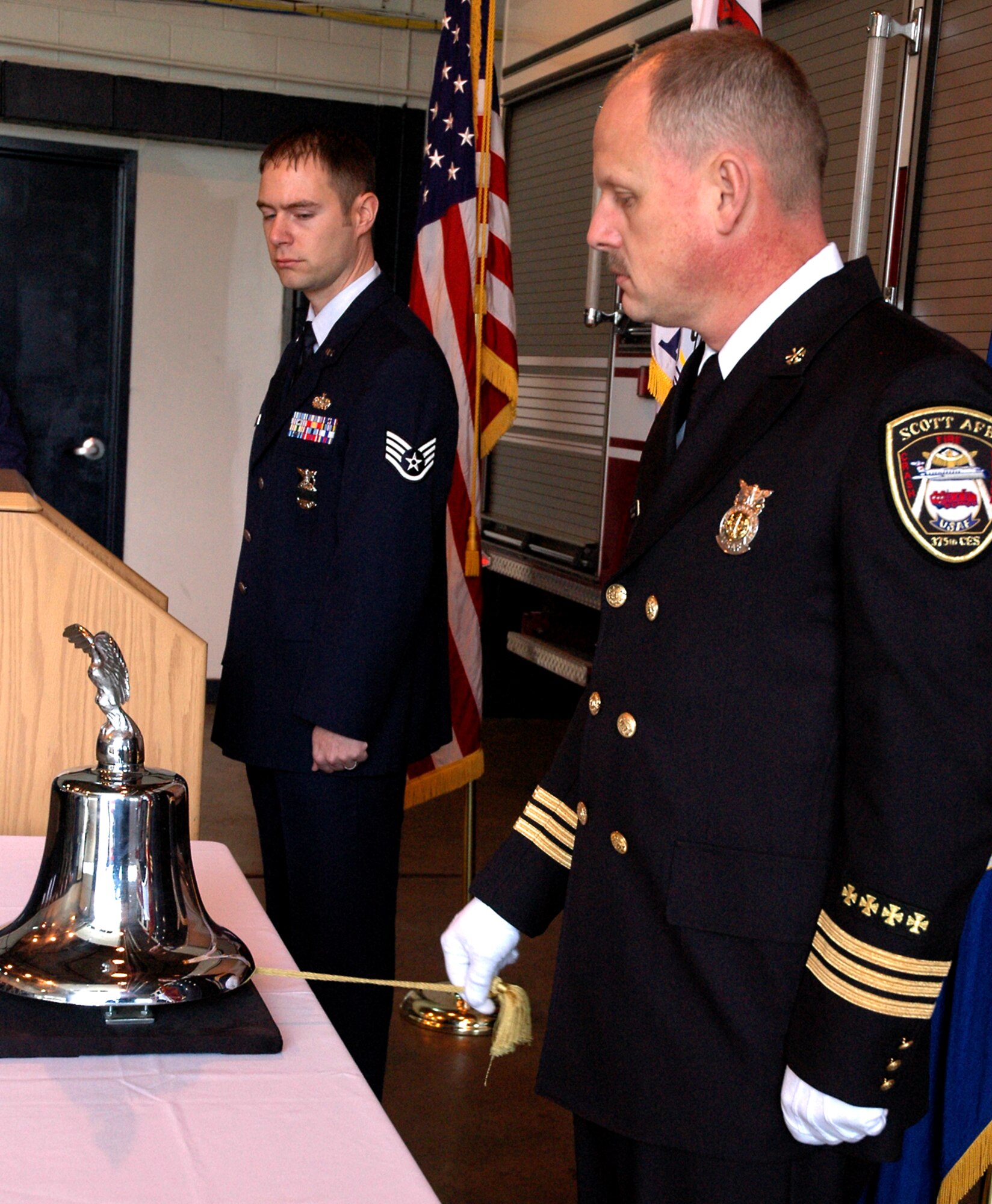 SCOTT AIR FORCE BASE, Ill -- Staff Sgt. Eric Belland watches as Keith Long, assistant fire chief, rings a fire bell here during a one-minute "final alarm" ceremony Feb. 16 honoring Staff Sgt. Ray Rangel who died while attempting to rescue two Soldiers after their 