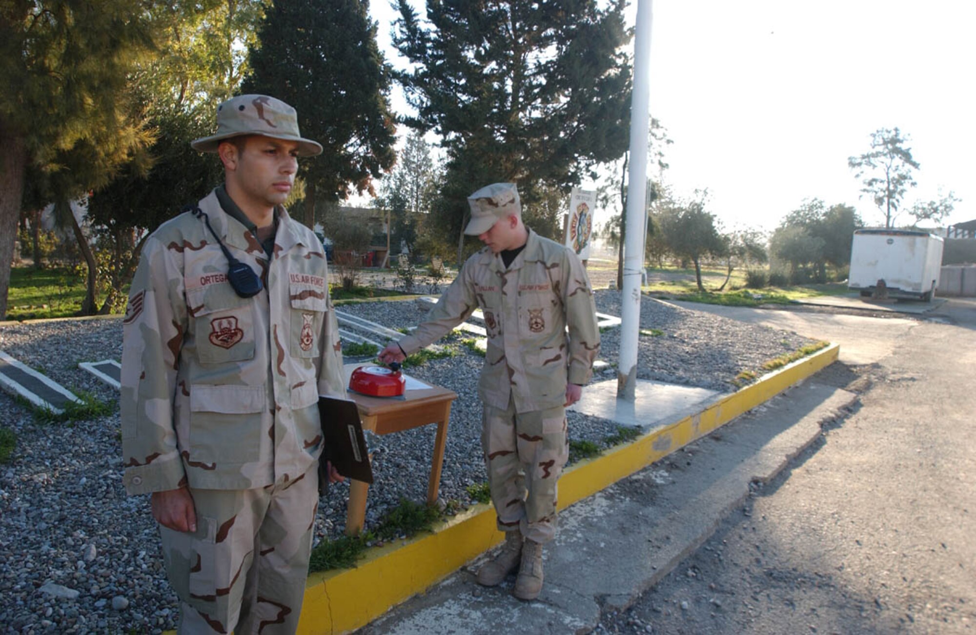 KIRKUK AIR BASE, Iraq -- Staff Sgt. Jesus Ortega III stands at attention as fellow firefighter Airman Peter Callan rings a bell during a one-minute "final alarm" ceremony Feb. 16 honoring Staff Sgt. Ray Rangel who died while attempting to rescue two Soldiers after their Humvee overturned in a canal in Iraq.  Sergeant Ortega and Airman Callan are firefighters with the 506th Expeditionary Civil Engineer Squadron here.  (U.S. Air Force photo by Staff Sgt. Matthew Lohr)
