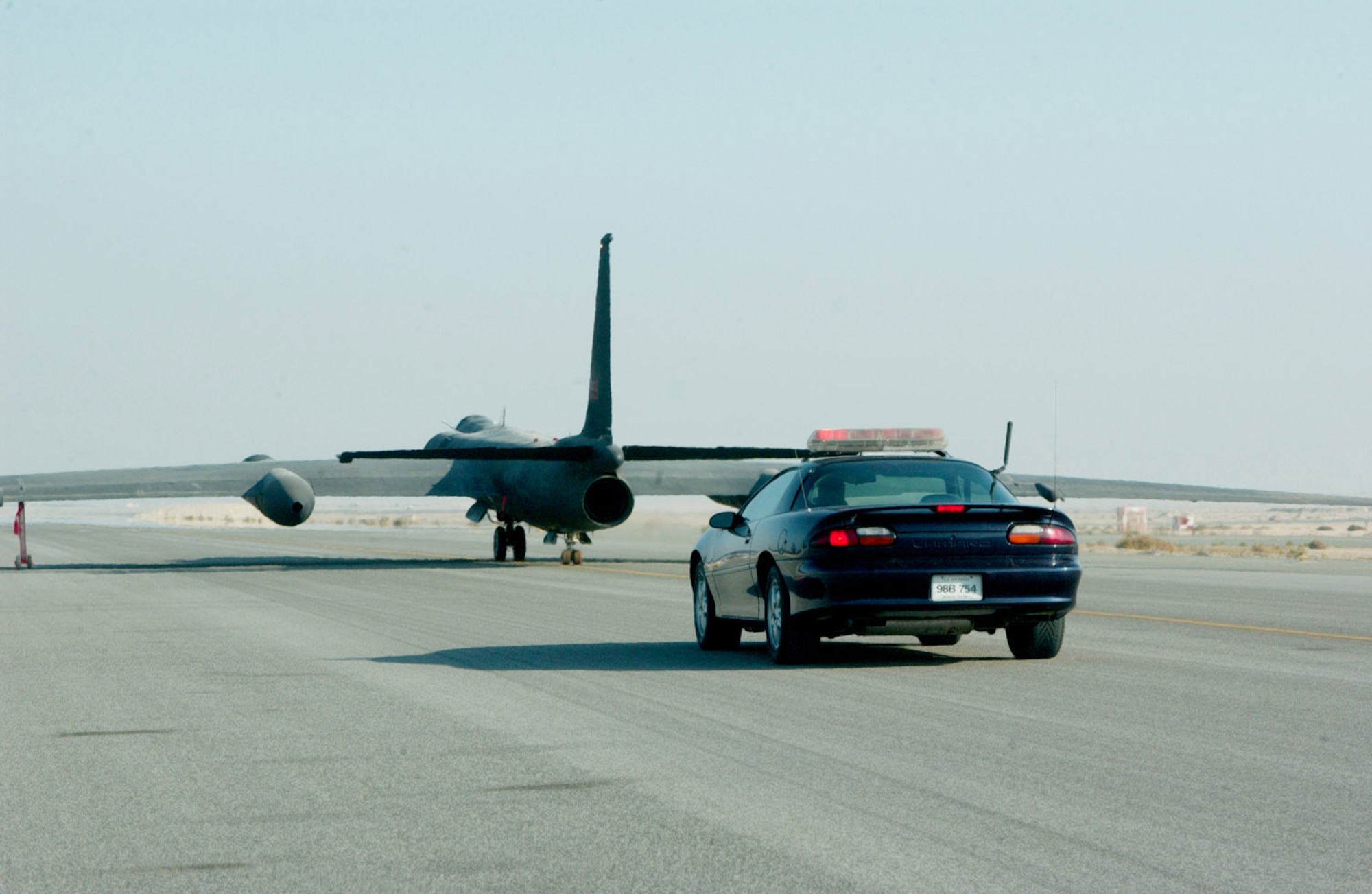 SOUTHWEST ASIA -- A Chevrolet Camaro Z-28 chases a U-2 Dragon Lady down the runway here.  Because of visibility limitations when on the ground, U-2 pilots rely on the driver in the car to provide information during takeoffs and landings.  (U.S. Air Force photo by Staff Sgt. Justin Jacobs)