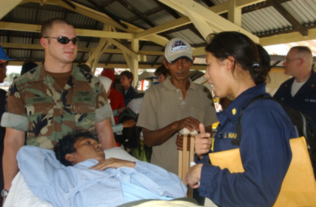 Navy Lt. j.g. Maria Collier and Seaman James Vanroy comfort a patient about to be airlifted to the hospital ship USNS Mercy (T- AH 19) for treatment on Feb. 19, 2005. Mercy is currently on station off the coast of Banda Aceh, Sumatra, Indonesia, providing medical assistance and disaster relief in conjunction with non-governmental organizations to the people of Indonesia affected by the devastating tsunami that hit Southeast Asia on Dec. 26. 