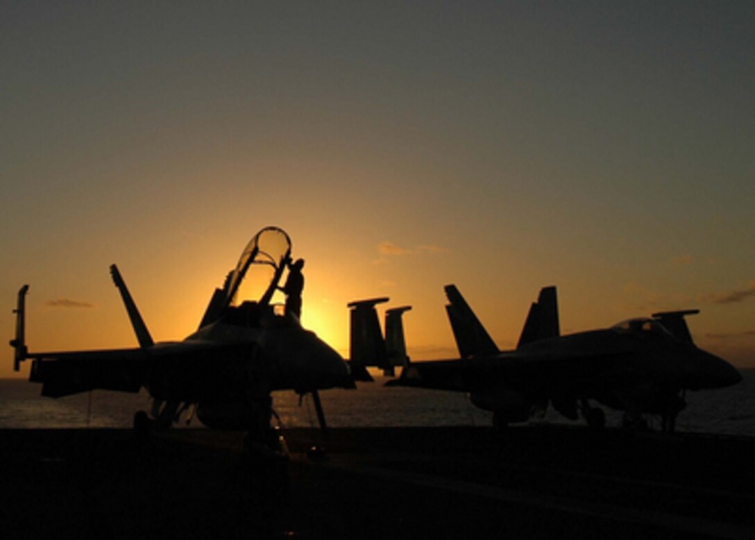 A plane captain wipes down the canopy of an F/A-18F Super Hornet after securing from flight operations aboard the USS Abraham Lincoln (CVN-72) on Feb. 20, 2005. Lincoln and its embarked Carrier Air Wing 2 are currently deployed to the Western Pacific Ocean. 