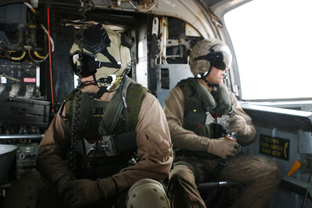 Cpl. Dusty L. Thorman, 22, an aerial observer with Marine Medium Helicopter Squadron 165 (REIN), and a native of Cleburne, Texas, and Lance Cpl. Joshua R.C. Smith, 21, a CH-46E crew chief, and native of Merrill, Ore., scout the area for their target during a live-fire exercise here. HMM-165 (REIN), attached to the 15th Marine Expeditionary Unit (Special Operations Capable), is training in Kuwait to maintain their skills as an Aviation Combat Element.