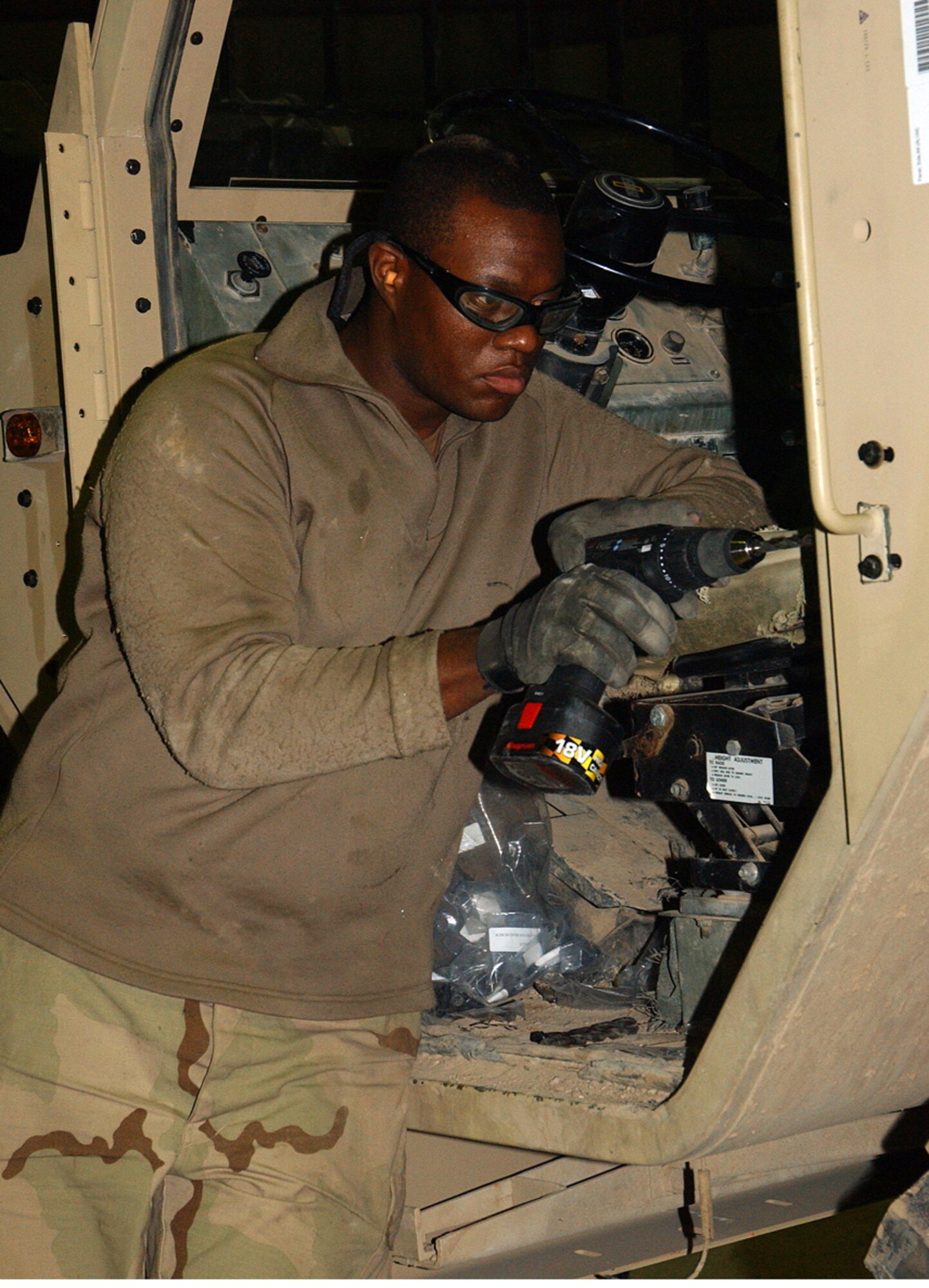 BALAD AIR BASE, Iraq -- Staff Sgt. Andre Collins drills holes into the side of an Army vehicle so a combat-lock door can be installed.  Sergeant Collins is a 732nd Expeditionary Logistics Readiness Squadron vehicle maintainer from Luke Air Force Base, Ariz.  (U.S. Air Force photo by Senior Airman Colleen Wronek) 