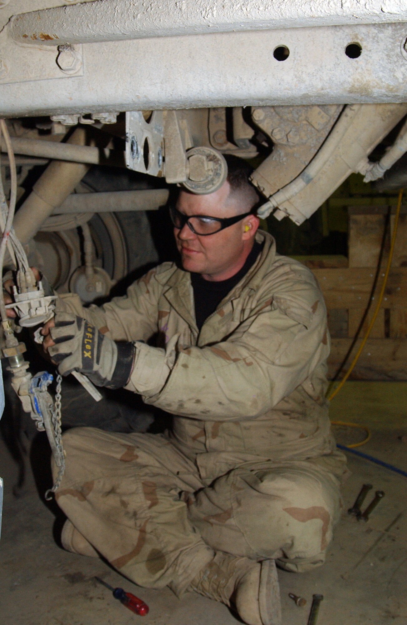 BALAD AIR BASE, Iraq -- Staff Sgt. Fulton Morris pulls down air lines while serving an Army vehicle.  He is a 732nd Expeditionary Logistics Readiness Squadron general purpose mechanic deployed from Dover Air Force Base, Del.  (U.S. Air Force photo by Senior Airman Colleen Wronek)