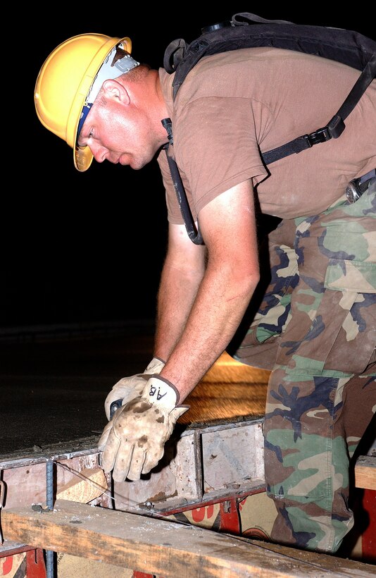 LAS FLORES, El Salvador -- Staff Sgt. Alan Baker smooths over the edge of a concrete foundation for a school here.  Reserve Airmen from Wright-Patterson Air Force Base, Ohio, are here supporting New Horizons 2005, a readiness training exercise providing humanitarian-assistance projects to help citizens of El Salvador.  The exercise hones the Airmen's skills as they build schools, clinics and other projects.  Sergeant Baker is assigned to the 445th Civil Engineer Squadron. (U.S. Air Force photo by Staff Sgt. Karen J. Tomasik)