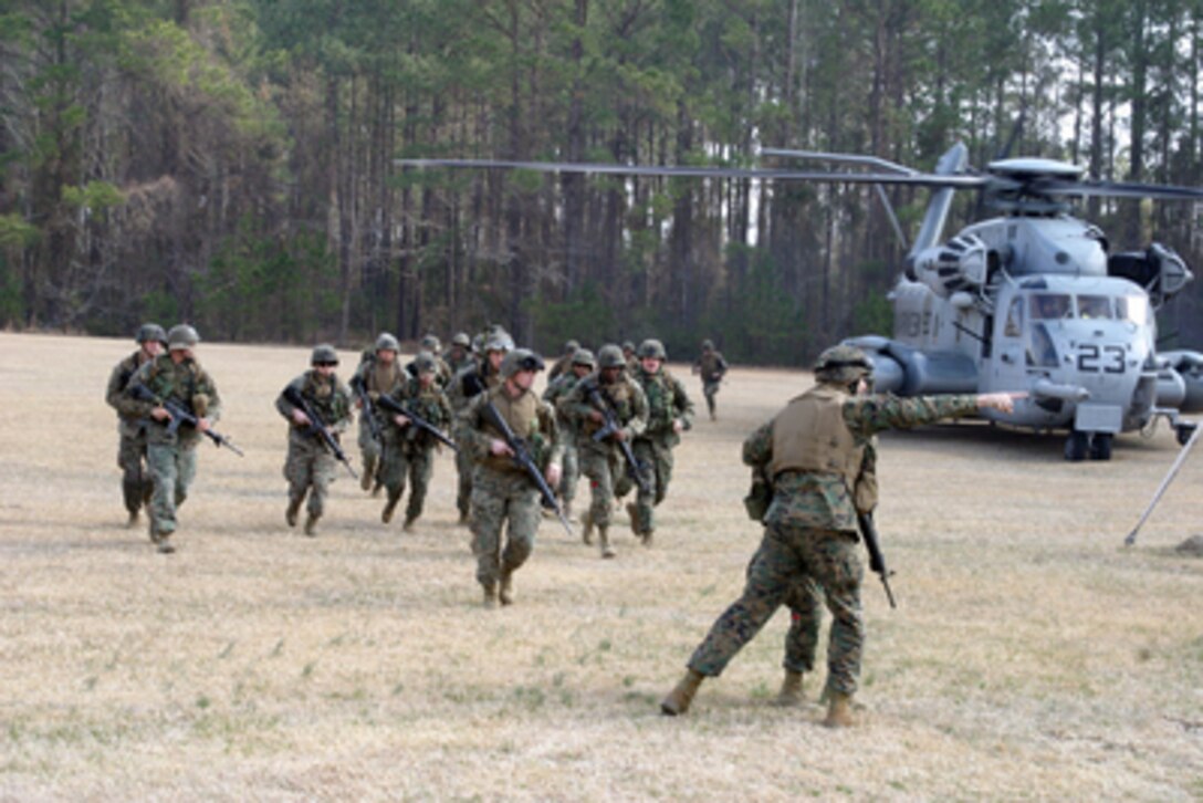 U.S. Marines and sailors are directed forward as they arrive at Camp Johnson, N.C., to process and evacuate role-playing U.S. citizens and third world nationals during a Non-combatant Evacuation Operation exercise on Feb. 22, 2005. The Evacuation Operation exercise is part of the 26th Marine Expeditionary Unit's certification as Special Operations Capable. The Marines and sailors are attached to Service Support Group 26. 