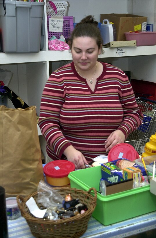 MARINE CORPS BASE CAMP LEJEUNE, N.C. - Katie Kuhnle, a volunteer at the Staff Noncommissioned Wives Club Thrift Shop, sorts through donations and looks for items that can be used in the store or be given to other charitable groups.  "We get so much donated from the community, it's great," said Kuhnle. "It definitely keeps us busy here."  The club raises money every year for organizations such as the Boys and Girl Scouts of America and the Veterans of Foreign Wars, as well as the SNCO Wives Club Scholarship. (Official Marine Corps photo by Lance Cpl. Shane Suzuki)