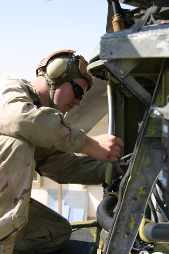 Lance Cpl. Lucas Rusch, flightline mechanic, Marine Medium Helicopter Squadron 264 checks some of the hoses in the front engine of Black Knight CH-46E during a 100-hour inspection.