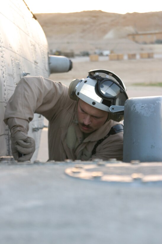 Master Sgt. Leonard Caires, quality assurance chief, HMM-264 and Salem, Mass. native, tightens down a panel during a pre-flight check on one of the squadrons CH-46E.