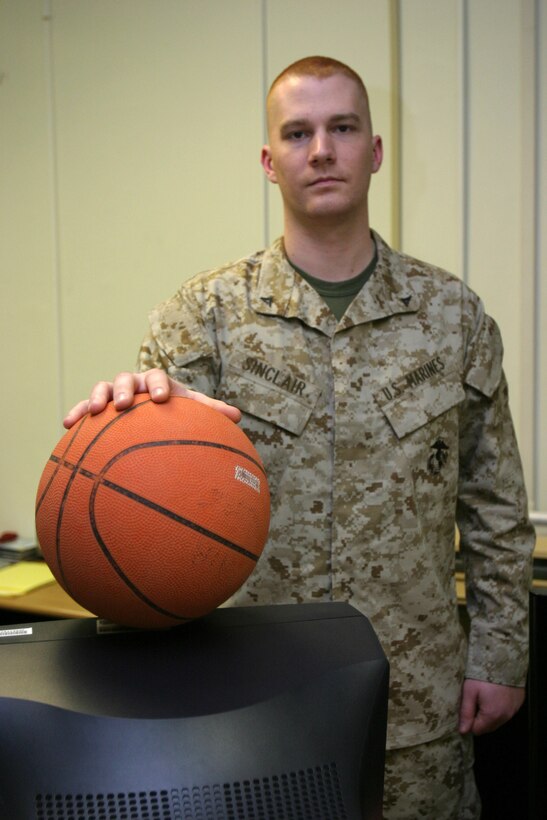 MARINE CORPS BASE CAMP LEJEUNE, N.C. - Lance Cpl. Joshua A. Sinclair, a Lansing, Mich. native and Marine Air Ground Task Force planner for 2d Marine Division holds a basketball near his work area, two things that make up the most of his life right now. Sinclair, along with the rest of his fellow Marines in Headquarters Battalion, is currently preparing to deploy in support of Operation Iraqi Freedom.