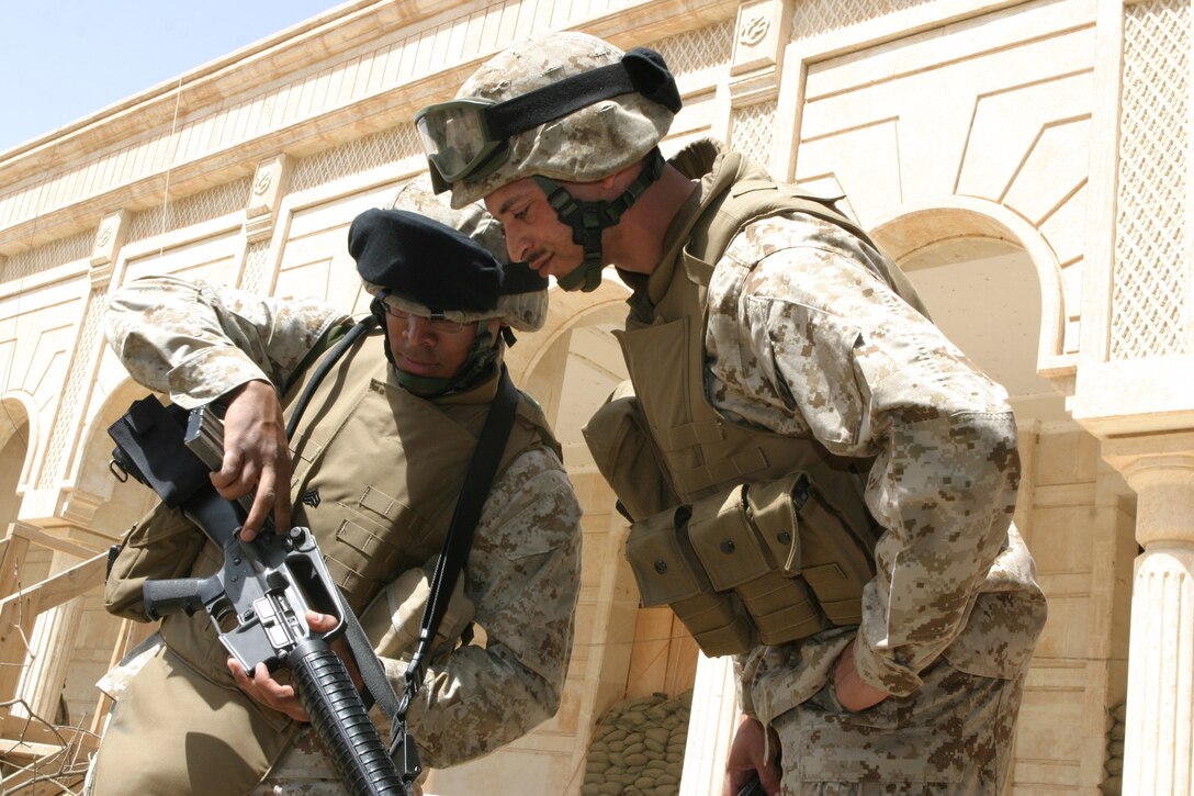 CAMP BLUE DIAMOND, AR RAMADI, Iraq -- Sergeant Curtis Proctor, a 29-year-old Riverside, Calif. checks the chamber of a rifle to see if it's cleared as his Marine on the camp guard force changes post, April 2.  Proctor is the common operational picture manager for the 2nd Marine Division operations section.  The father of four also holds the All-Marine Track Team record for the 200-meter sprint.  U.S. Marine Corps photo by Sgt. Stephen D'Alessio (RELEASED)