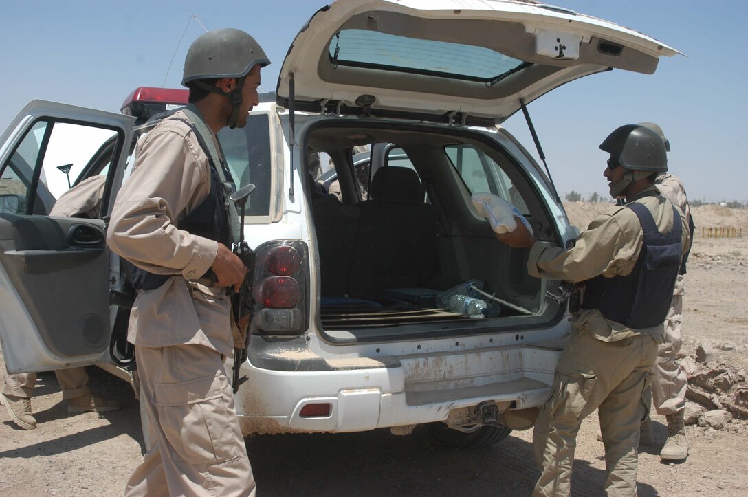 CAMP ALI Ar Ramadi, Iraq - Iraqi Security Forces search a vehicle during training session at a mock vehicle checkpoint here. Marines with the Combined Action Platoon, Company B, 1st Battalion, 5th Marine Regiment, are responsible for training new members of the Iraqi Security Forces during the infantry battalion's deployment in support of Operation Iraqi Freedom.   Photo by: Cpl. Tom Sloan