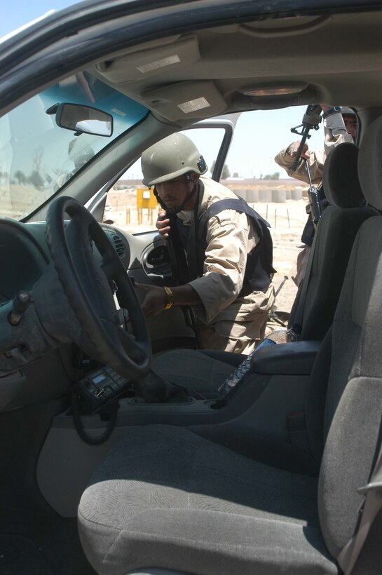 CAMP ALI Ar Ramadi, Iraq - A member of the Iraqi Security Forces searches a vehicle during a training session at a mock vehicle checkpoint here. Marines with the Combined Action Platoon, Company B, 1st Battalion, 5th Marine Regiment, are responsible for training new members of the Iraqi Security Forces during the infantry battalion's deployment in support of Operation Iraqi Freedom.   Photo by: Cpl. Tom Sloan