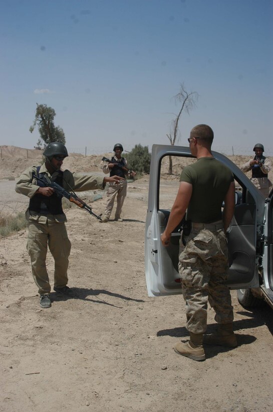 CAMP ALI Ar Ramadi, Iraq - An Iraqi soldier tells a Marine to stand away from his vehicle during training session at a mock vehicle checkpoint here. Marines with the Combined Action Platoon, Company B, 1st Battalion, 5th Marine Regiment, are responsible for training new members of the Iraqi Security Forces during the infantry battalion's deployment in support of Operation Iraqi Freedom. The platoon has trained 300 soldiers and 300 police officers since assuming the training role two months ago. Photo by: Cpl. Tom Sloan  Photo by: Cpl. Tom Sloan