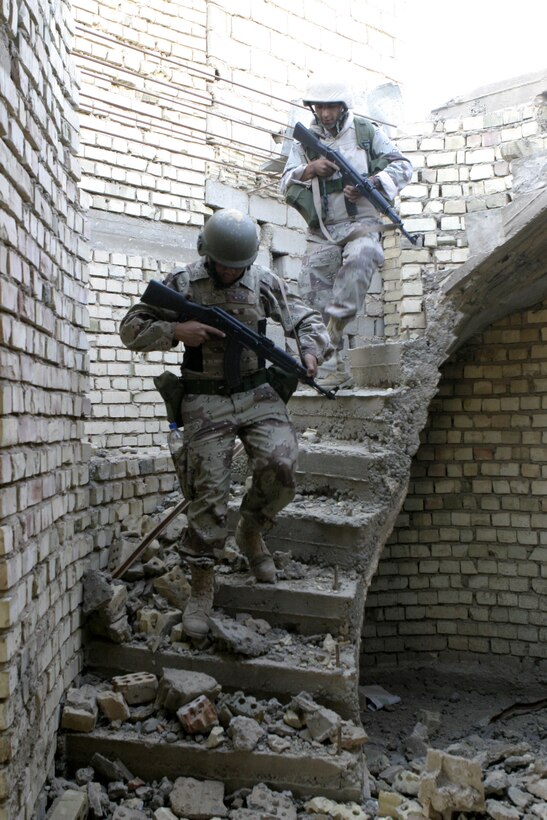 FALLUJAH, Iraq - Iraqi soldiers scramble down a flight of stairs inside a ruined home here June 1 during 'Operation Hard Knock.'  The soldiers worked alongside Marines from Company B, 1st Battalion, 6th Marine Regiment to search through every house and field in a sector of Fallujah, confiscate numerous weapons and explosive materials, and detain four known insurgent supporters.