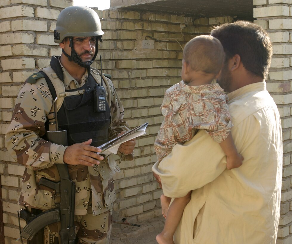 FALLUJAH, Iraq - An Iraqi officer speaks with a resident outside his home here June 1 to gather information and explain the purpose behind 'Operation Hard Knock.'  The soldiers worked alongside Marines from Company B, 1st Battalion, 6th Marine Regiment to search through every house and field in a sector of Fallujah, confiscate numerous weapons and explosive materials, and detain four known insurgent supporters.