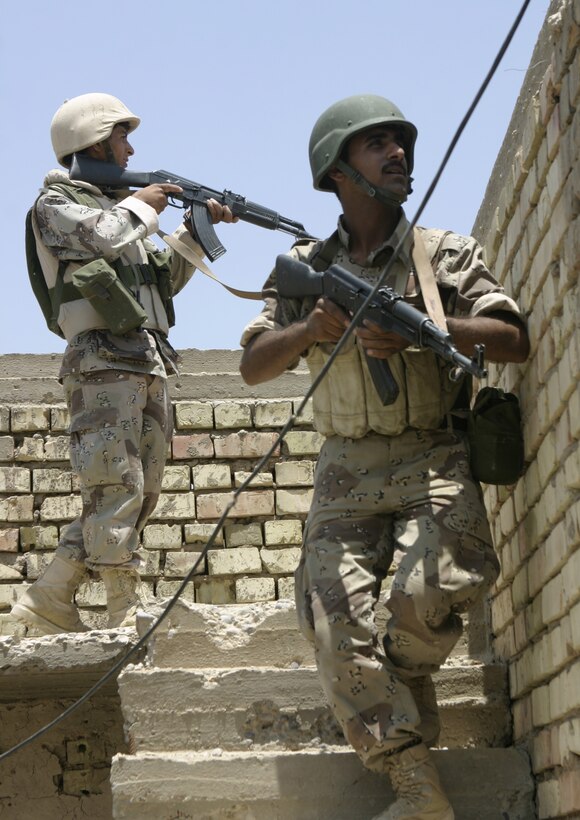 FALLUJAH, Iraq - Two Iraqi soldiers search through a ruined house here June 1 during 'Operation Hard Knock.'  The soldiers worked alongside Marines from Company B, 1st Battalion, 6th Marine Regiment to search through every house and field in a sector of Fallujah, confiscate numerous weapons and explosive materials, and detain four known insurgent supporters.