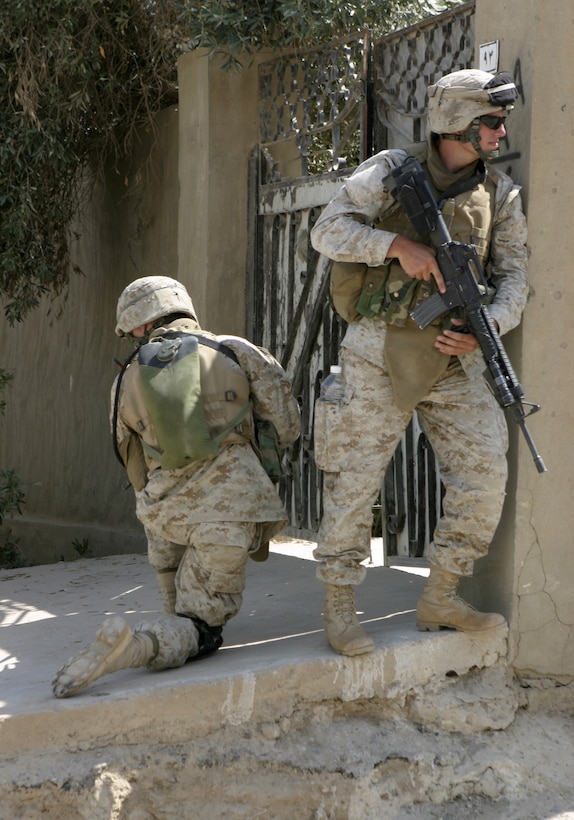 FALLUJAH, Iraq - Two Marines with Company B, 1st Battalion, 6th Marine Regiment provide security at a street corner here June 1 during 'Operation Hard Knock.'  U.S. Marines worked alongside Iraqi soldiers to search through every house and field in a sector of Fallujah, confiscate numerous weapons and explosive materials, and detain four known insurgent supporters.