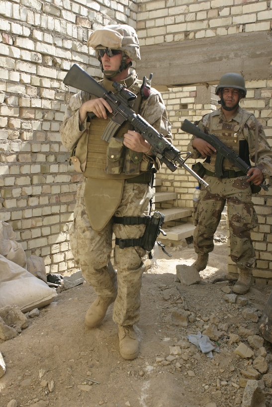 FALLUJAH, Iraq - A Marine with Company B, 1st Battalion, 6th Marine Regiment searches through a ruined house alongside an Iraqi soldier while conducting 'Operation Hard Knock' here June 1.  U.S. Marines worked alongside Iraqi soldiers to search through every house and field in a sector of Fallujah, confiscate numerous weapons and explosive materials, and detain four known insurgent supporters.