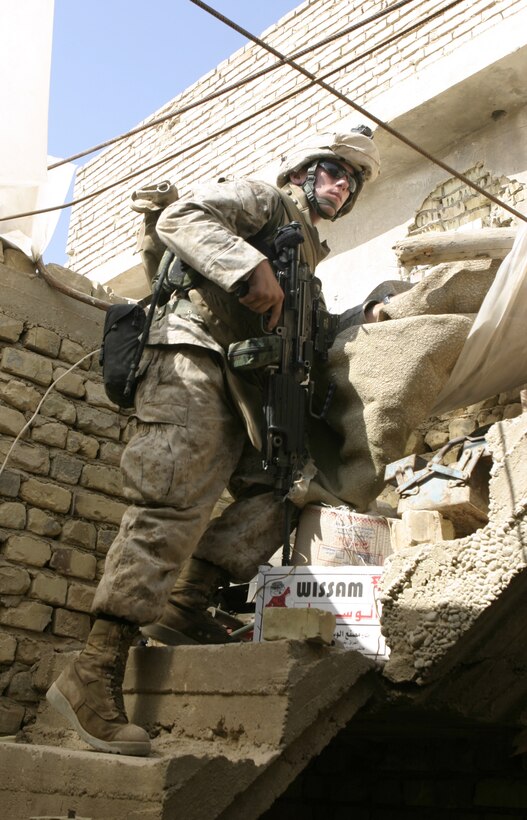 FALLUJAH, Iraq - Lance Cpl. Dean A. Paxton, an M249 squad automatic gunner with 3rd Platoon, Company B, 1st Battalion, 6th Marine Regiment, searches through a ruined home here June 1 during 'Operation Hard Knock.'  U.S. Marines worked alongside Iraqi soldiers to search through every house and field in a sector of Fallujah, confiscate numerous weapons and explosive materials, and detain four known insurgent supporters.  Photo by: Cpl Mike Escobar
