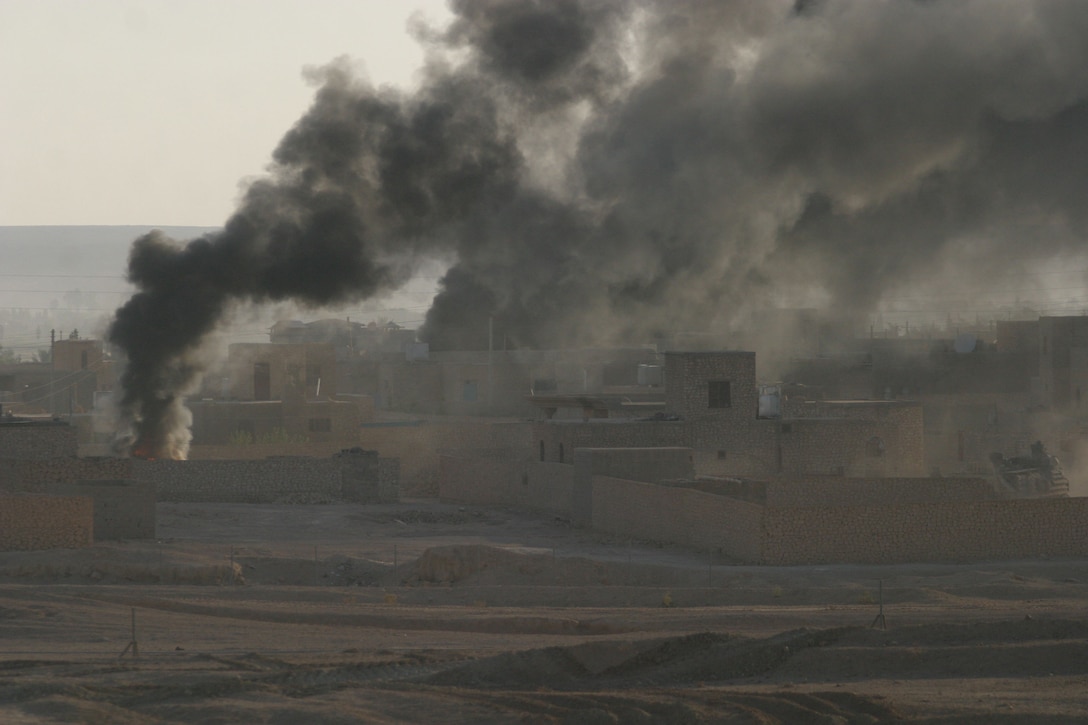 KARABILAH, Iraq- (June 17, 2005)  Marines and members of the Iraqi Security Force watch as smoke pours from an abandoned vehicle in Karabilah.  Operation Spear is conducted to destroy insurgency leadership strong points. (Official USMC photo by Cpl Neill A. Sevelius)( RELEASED)