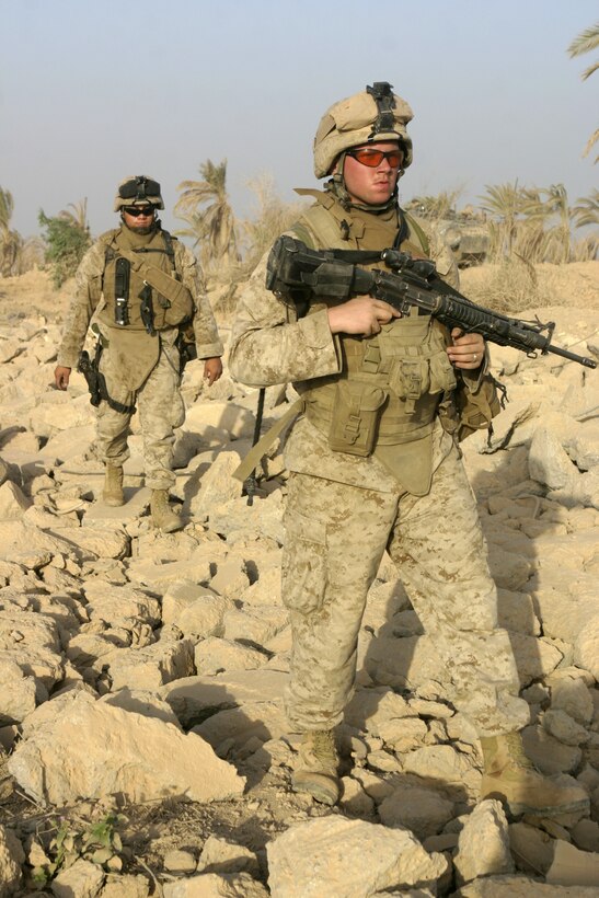 THAR THAR REGION, Iraq - Lance Cpl. Anthony Lazzarotto, a rifleman with 2nd Squad, 2nd Platoon, Company B, 1st Battalion, 6th Marine Regiment, leads Hospitalman Hans Valentine, a corpsman with 2nd Platoon, Company B, through building ruins here June 19.  Lazzarotto's unit is currently conducting security and stability operations in Iraq's Al Anbar province.