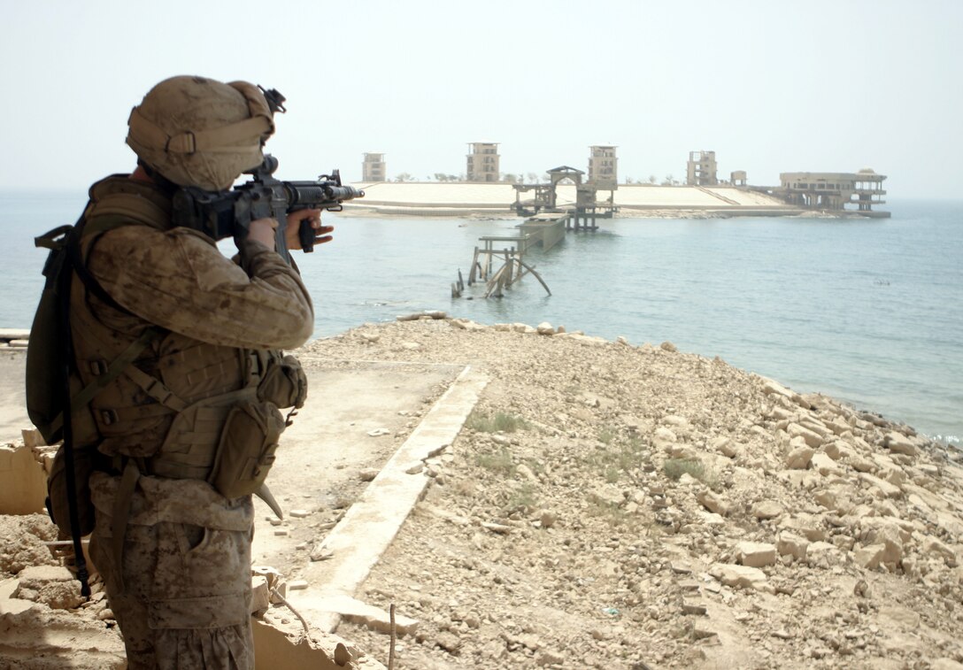 THAR THAR REGION, Iraq - Lance Cpl. Anthony Lazzarotto, a rifleman with 2nd Squad, 2nd Platoon, Company B, 1st Battalion, 6th Marine Regiment, looks through his rifle-mounted scope as he scans the shorelines of the Thar Thar Lake June 19.  Lazzarotto's unit is currently conducting security and stability operations in Iraq's Al Anbar province.