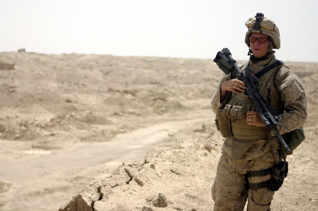 THAR THAR REGION, Iraq - Lance Cpl. Anthony Lazzarotto, a team leader with 2nd Squad, 2nd Platoon, Company B, 1st Battalion, 6th Marine Regiment, pauses atop a dirt hill while patrolling the deserts north of Fallujah in search of buried weapons and explosives.  The 23-year-old La Habra, Calif. native is currently conducting security and stability operations in Iraq's Al Anbar province.