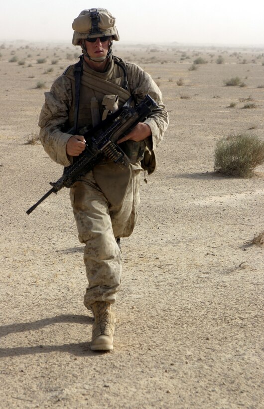 THAR THAR REGION, Iraq - Lance Cpl. Michael Harres, a squad automatic weapon gunner with 2nd Squad, 2nd Platoon, Company B, 1st Battalion, 6th Marine Regiment, patrols through the deserts north of Fallujah June 21 in search of buried weapons and explosives.  The 19-year-old Brooksville, Fla. native's unit is currently conducting security and stability operations in Iraq's Al Anbar province.