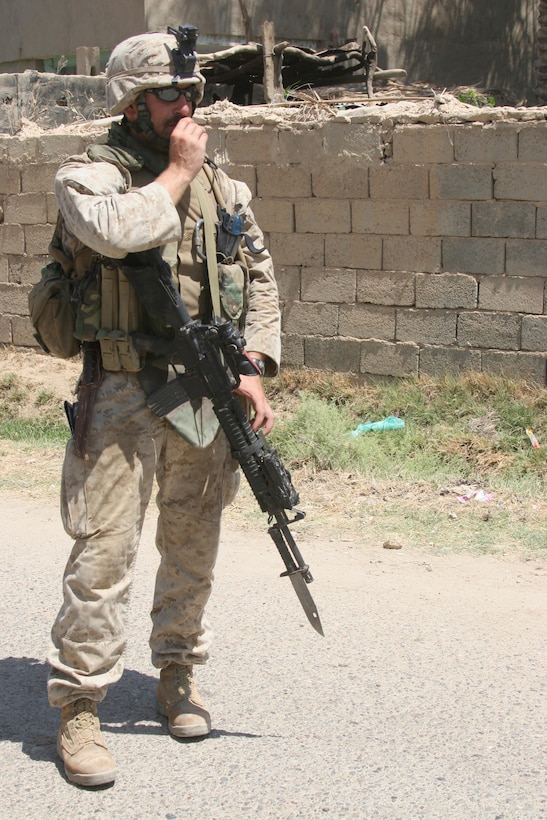 HIT, Iraq (July 1, 2005)- Sgt. James Angelone, the squad leader of 1st Squad, 1st Platoon, Company K, 3rd Battalion, 25th Marine Regiment, Regimental Combat Team-2 radios in during a patrol and cordon and knock in the city during Operation Guardian Sword conducted to clear the city and set-up Iraqi Security Forces firm bases through out the city. The Marines of 2d Marine Division conduct counter-insurgency operations with Iraqi Security Forces to isolate and neutralize anti-Iraqi forces, to support the continued development of Iraqi Security Forces, and to support Iraqi reconstruction and democratic elections in order to create a secure environment that enables Iraqi self-reliance and self-governance. (Official USMC photo by Lance Cpl. Lucian Friel )(NOT RELEASED)