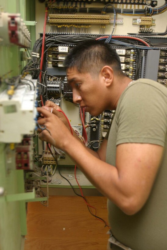 HADITHA DAM, Iraq (Oct. 16, 2005) - Lance Cpl. Roly Ramos, a Miami native and electrician attached to 3rd Battalion, 1st Marine Regiment, fixes a circuit breaker box in order to supply the more than 1,000 Marines aboard the dam here. The Bolivian-born Marine works countless hours as the only electrician in the battalion to maintain power so Marines can continue to do their jobs supporting of Operation Iraqi Freedom. (Official Marine Corps photo by Cpl. Adam C. Schnell)
