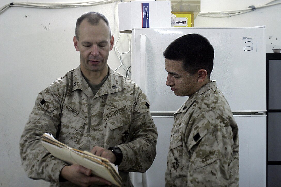 Camp Ripper, Iraq (October 26, 2005)-- Regimental Combat Team-2 awards officer Capt. Darrel L. Choat, 42-year-old Albion, Neb., native, and Cpl. Paul N. Ibarra, a 20-year-old Brooklyn-Mill Basin, N.Y., native, and administrative clerk discuss work while working late one night. (Official USMC Photo by Corporal Ken Melton)
