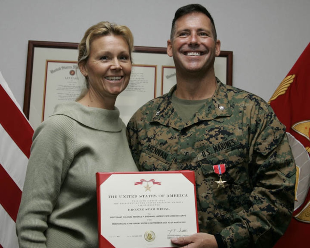 MARINE CORPS BASE CAMP LEJEUNE, N.C. - Lieutenant Colonel Terence P. Brennan, commanding officer for Headquarters Battalion, 2nd Marine Division, smiles for a photo with his wife, Kristi Brennan, being presented the Bronze Star Medal here Nov. 1.  The 45-year-old Little Compton, R.I. native received the nation's fourth highest award for his superior leadership while commanding his former artillery unit, 2nd Battalion, 10th Marine Regiment, during a recent deployment to Iraq's turbulent Al Anbar province.