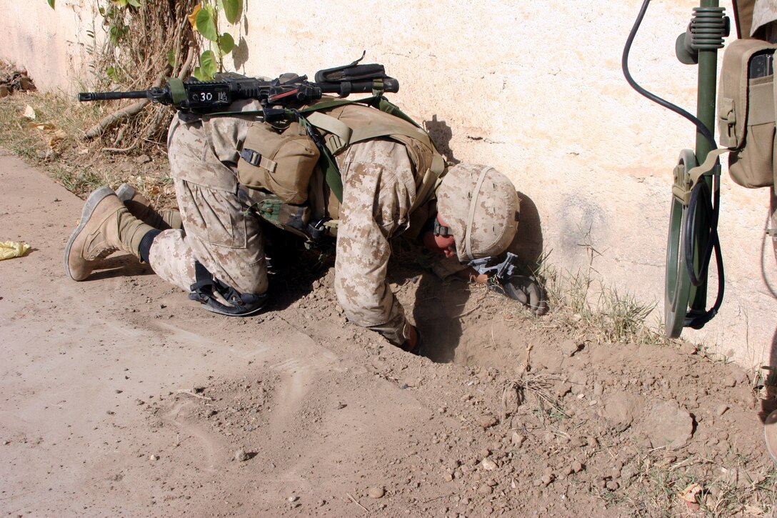 AR RAMADI, Iraq (November 1, 2005) - Sergeant Elias Gonzalez, a combat engineer with 2nd Platoon, Company C, 1st Combat Engineer Battalion, searches for possible improvised explosive devices and weapons caches during a raid Nov. 1. Photo by Cpl. Shane Suzuki